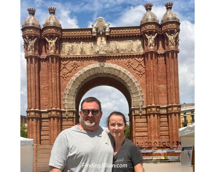 couple (findingjillian.com) standing in front of the Arche de triomphe in Barcelona